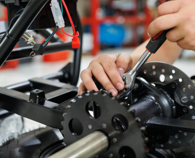 Worker make a ATV in the workshop. Preparing the quad bike for sale