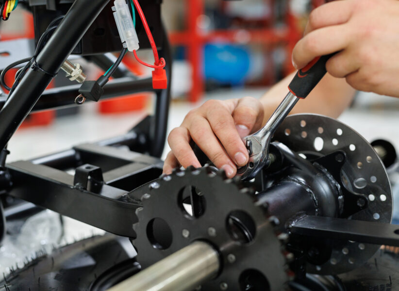Worker make a ATV in the workshop. Preparing the quad bike for sale